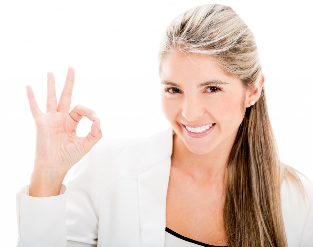 Business woman making an ok sign - isolated over white